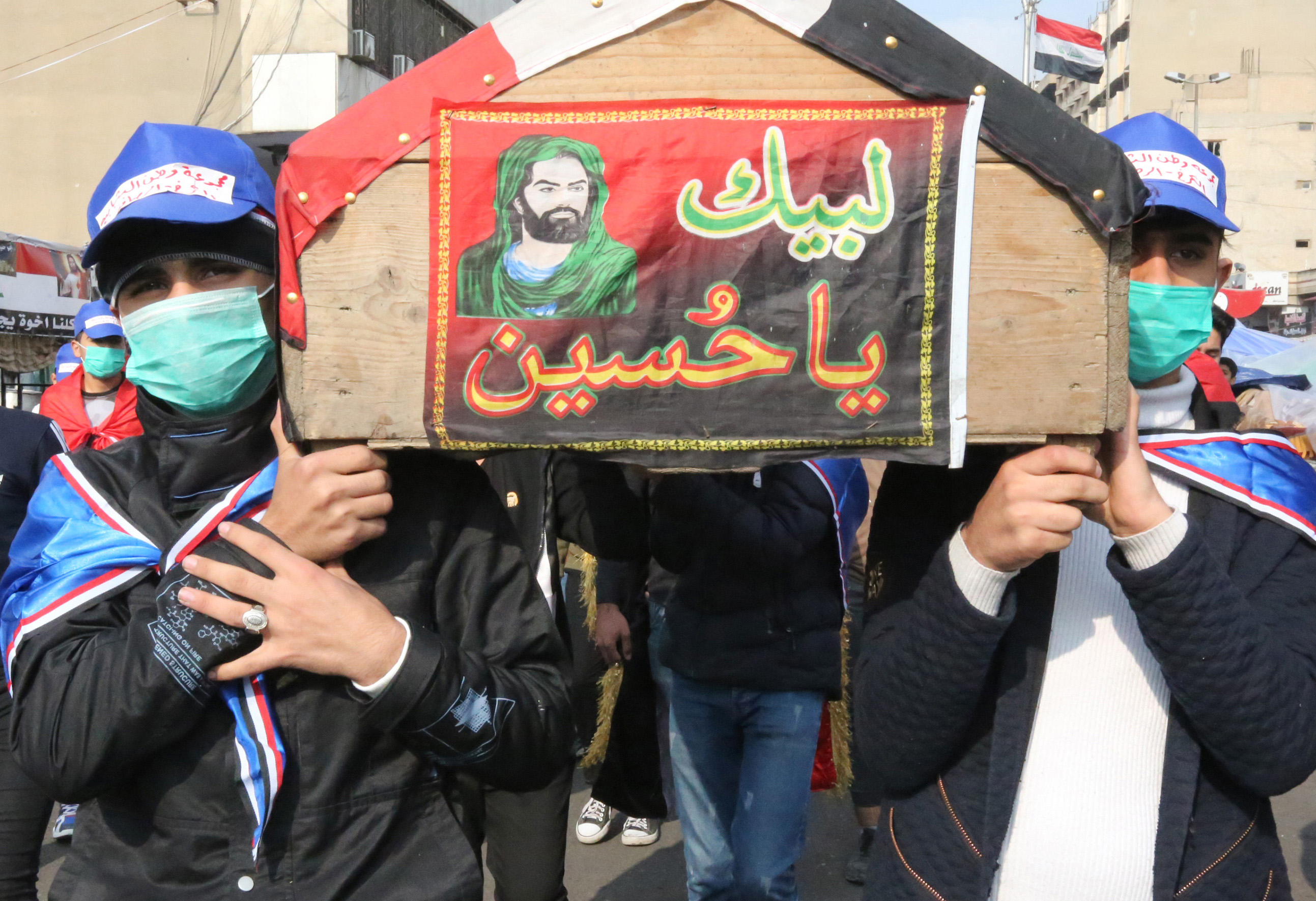 Iraqi demonstrators carry a mock coffin as they march in a symbolic funeral procession in Tahrir square in the capital Baghdad on December 8, 2019