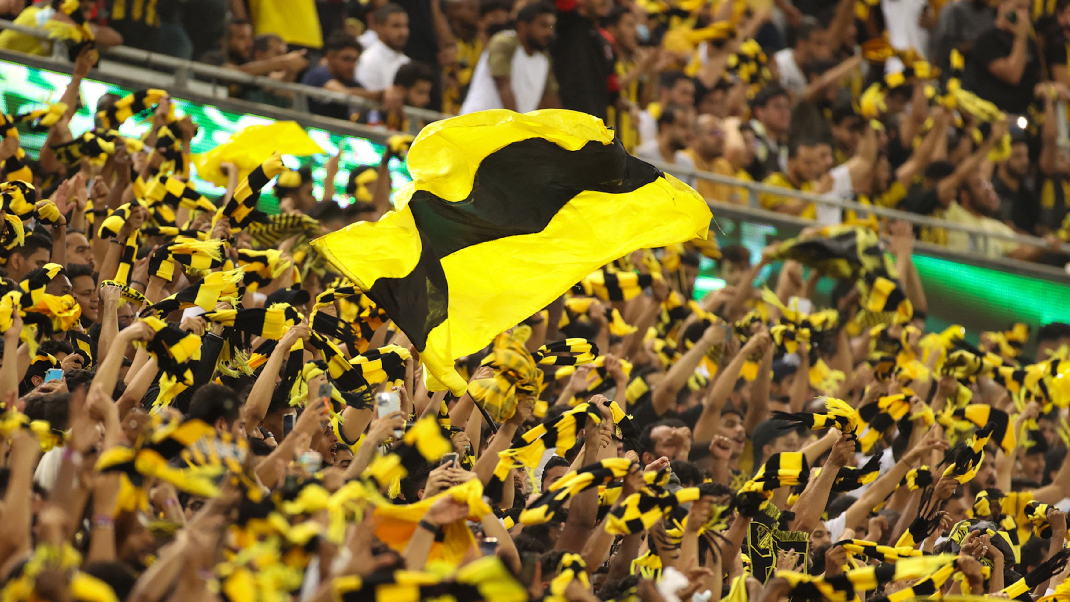 Supporters of joint league leaders al-Ittihad FC cheer during the Saudi Pro League football match against al-Hilal at the King Abdullah Sports City in Jeddah on 23 May 2022 (AFP)
