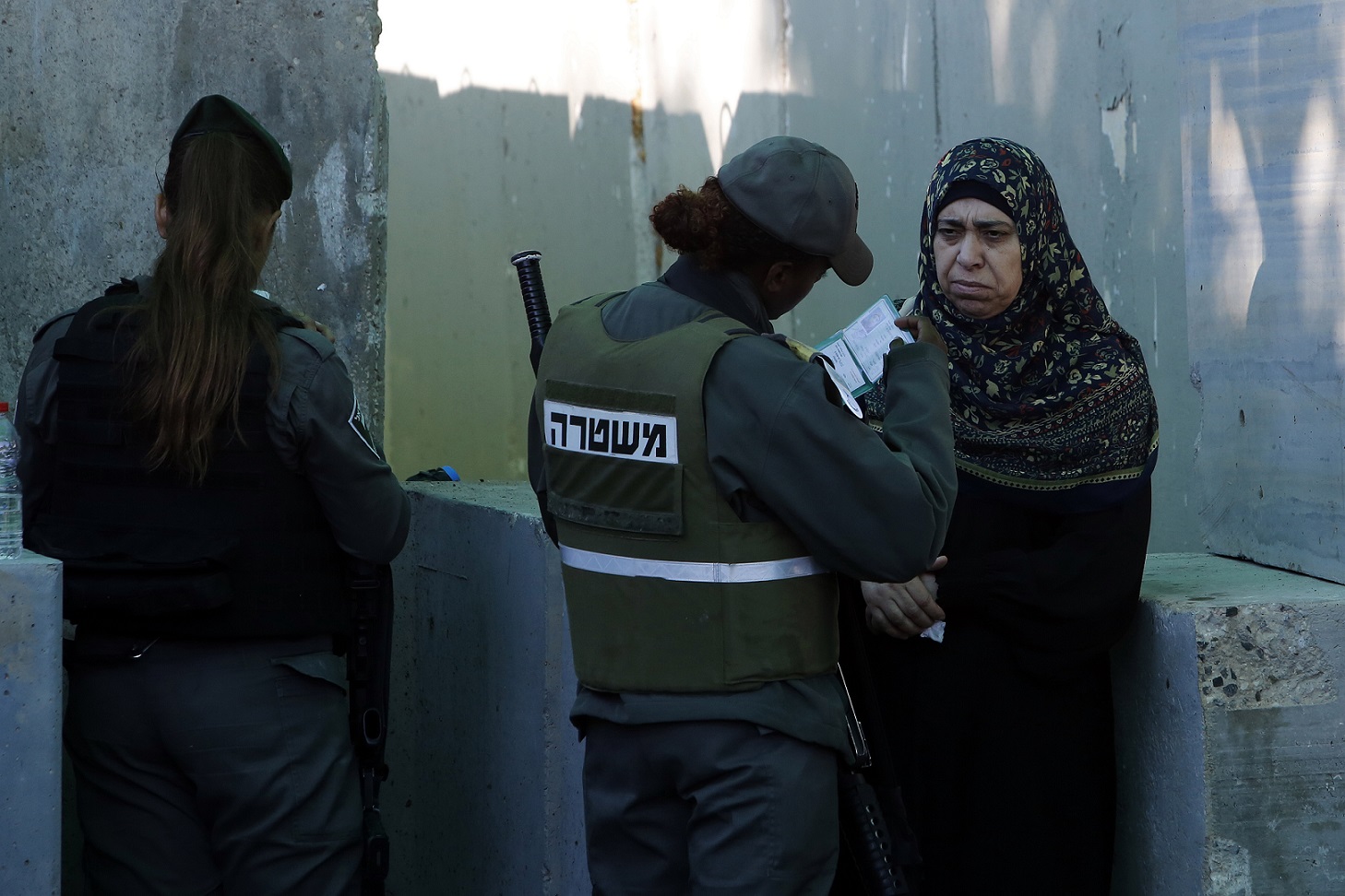 Des soldats israéliens contrôlent les documents d’identité d’une Palestinienne à un check-point situé entre Bethléem et Jérusalem pendant le Ramadan, le 2 juin 2017 (AFP)