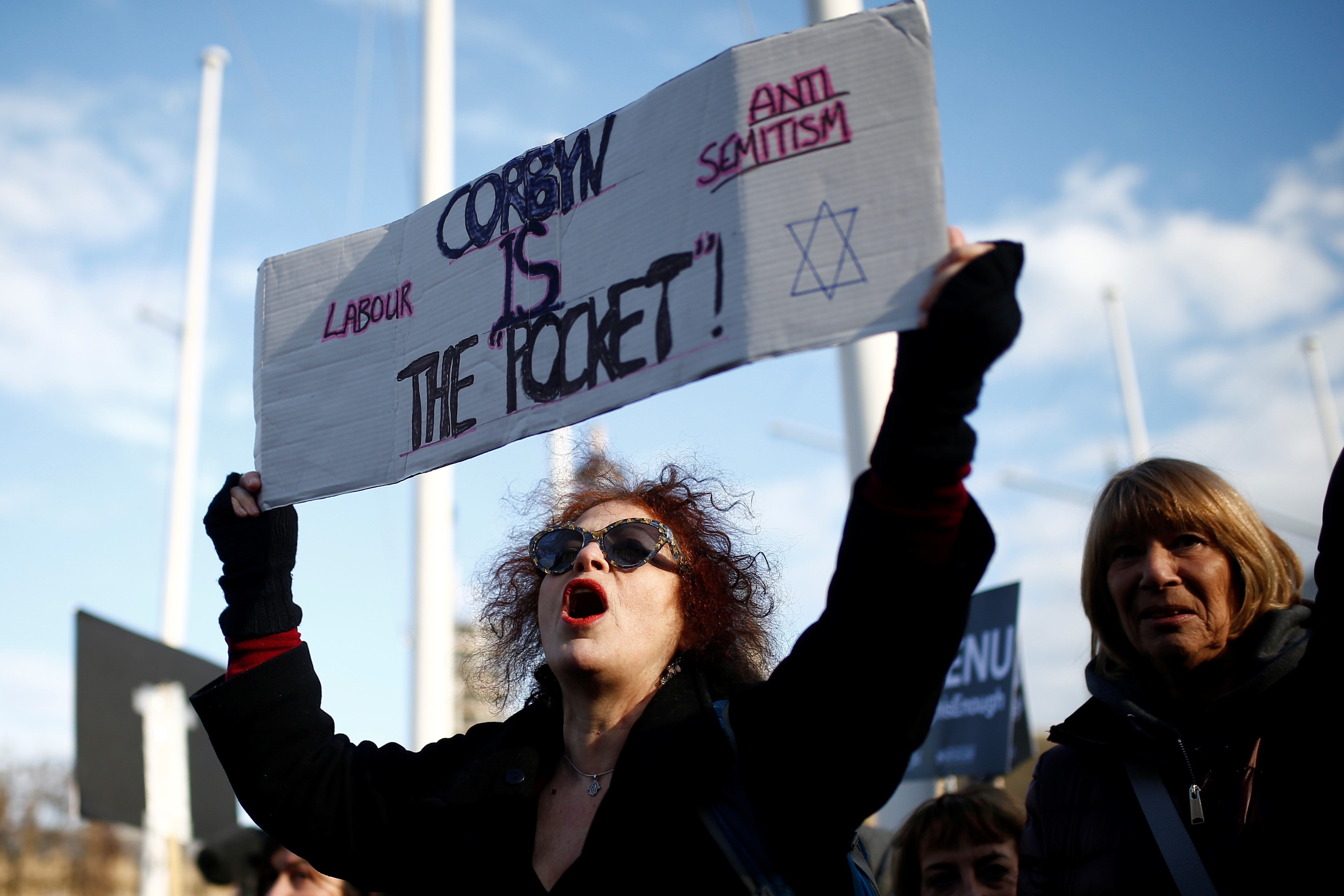 Protesters hold placards and flags during a demonstration, organised by the British Board of Jewish Deputies for those who oppose anti-Semitism, in Parliament Square in London, Britain, March 26, 2018