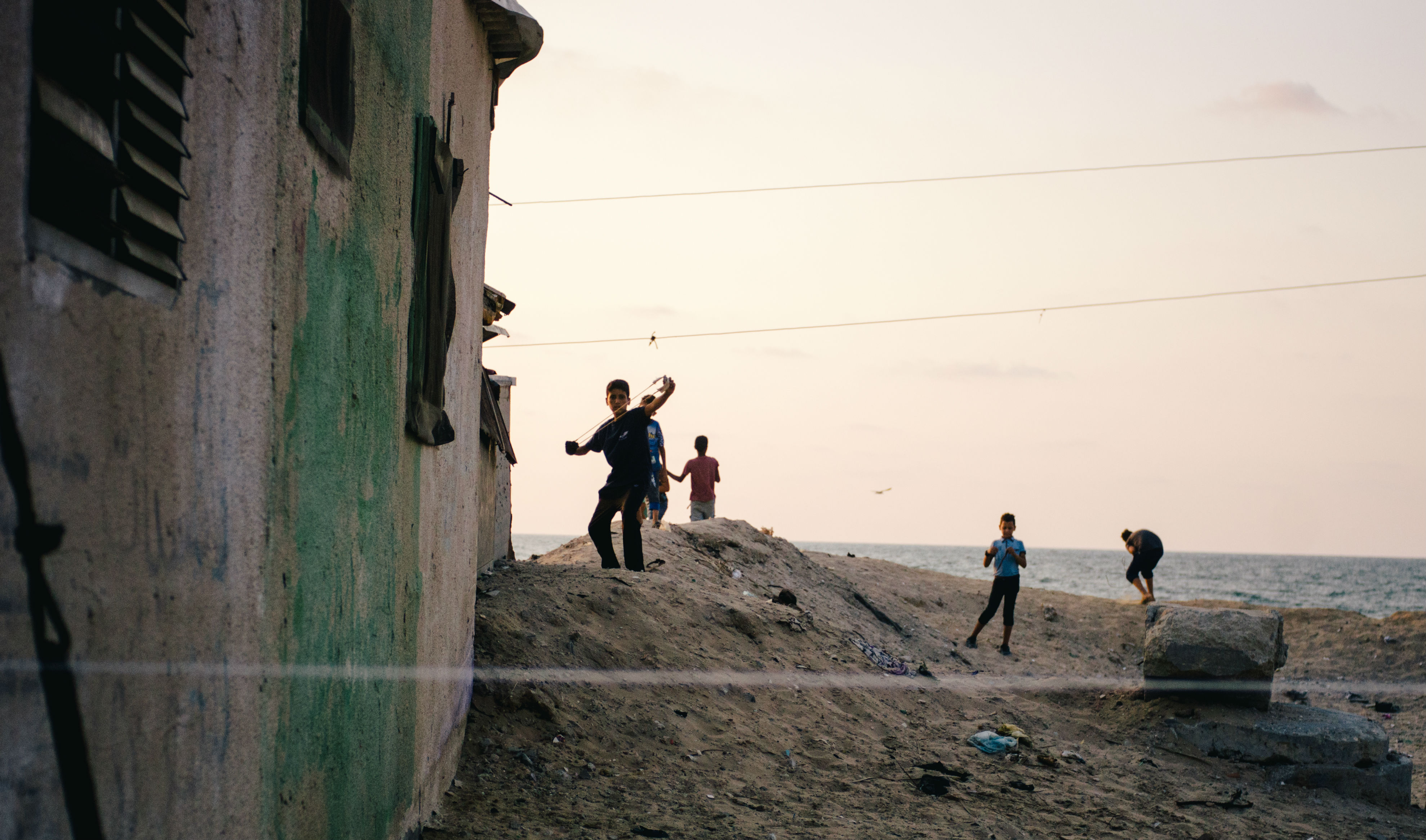 As the men and older teens weave the ropes for fishing nets, Shati camp's kids play on the shore, flinging stones into the Mediterranean with their sling shots. Only metres away a wastewater pipe pumps sewage into the sea