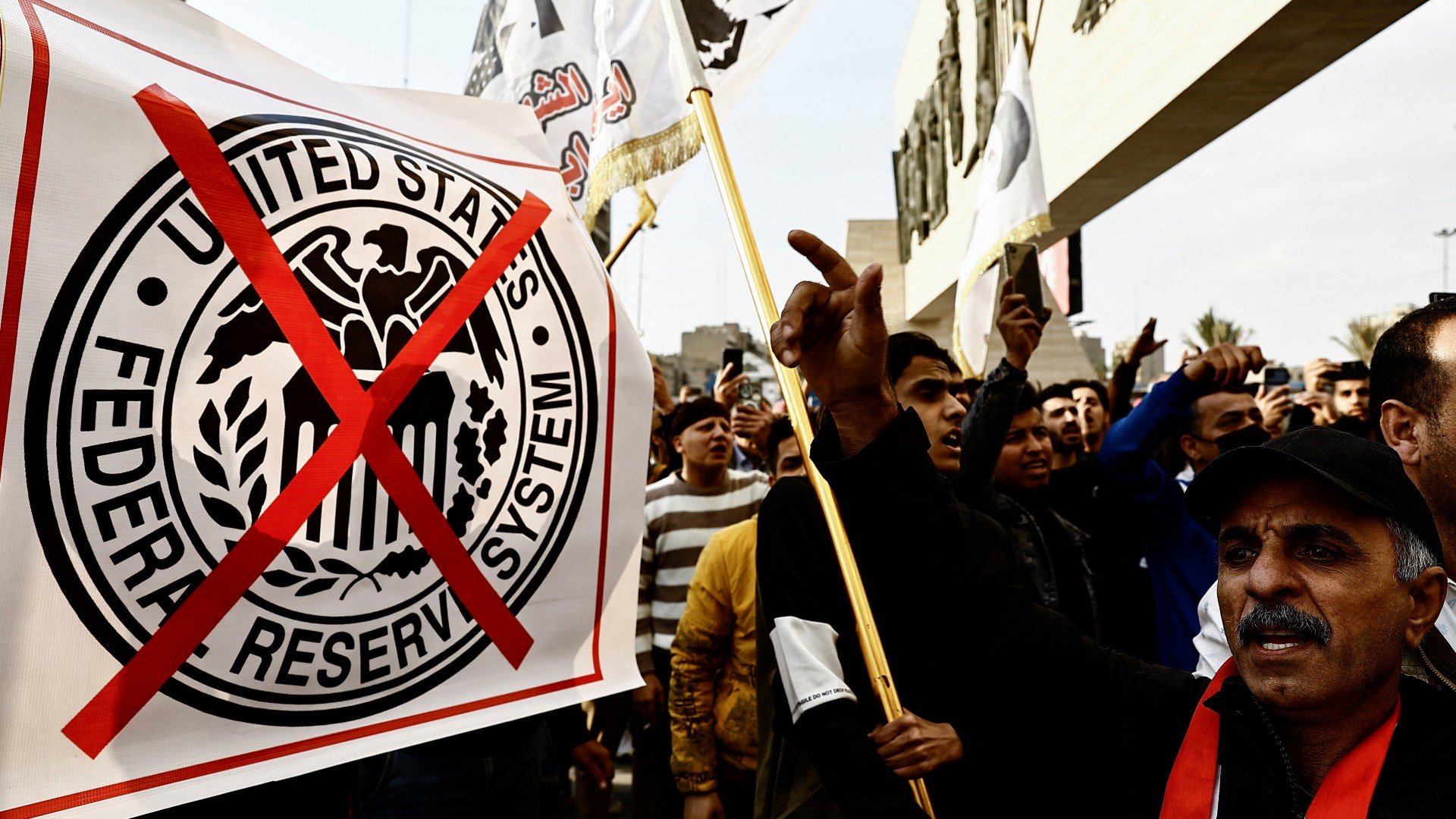 Iraqi protesters demonstrate against the dinar's slide in value against the US dollar in Baghdad, 3 February (Reuters)