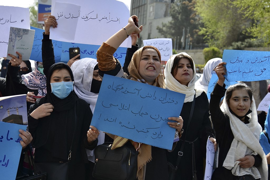 Afghan women and girls take part in a protest in front of the Ministry of Education in Kabul on 26 March 2022, demanding that high schools be reopened for girls (AFP)