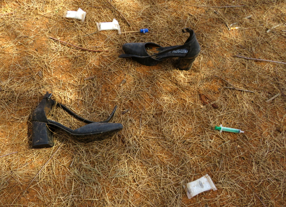 A pair of high heels next to a bullet hole-ridden car (MEE/Daniel Hilton)