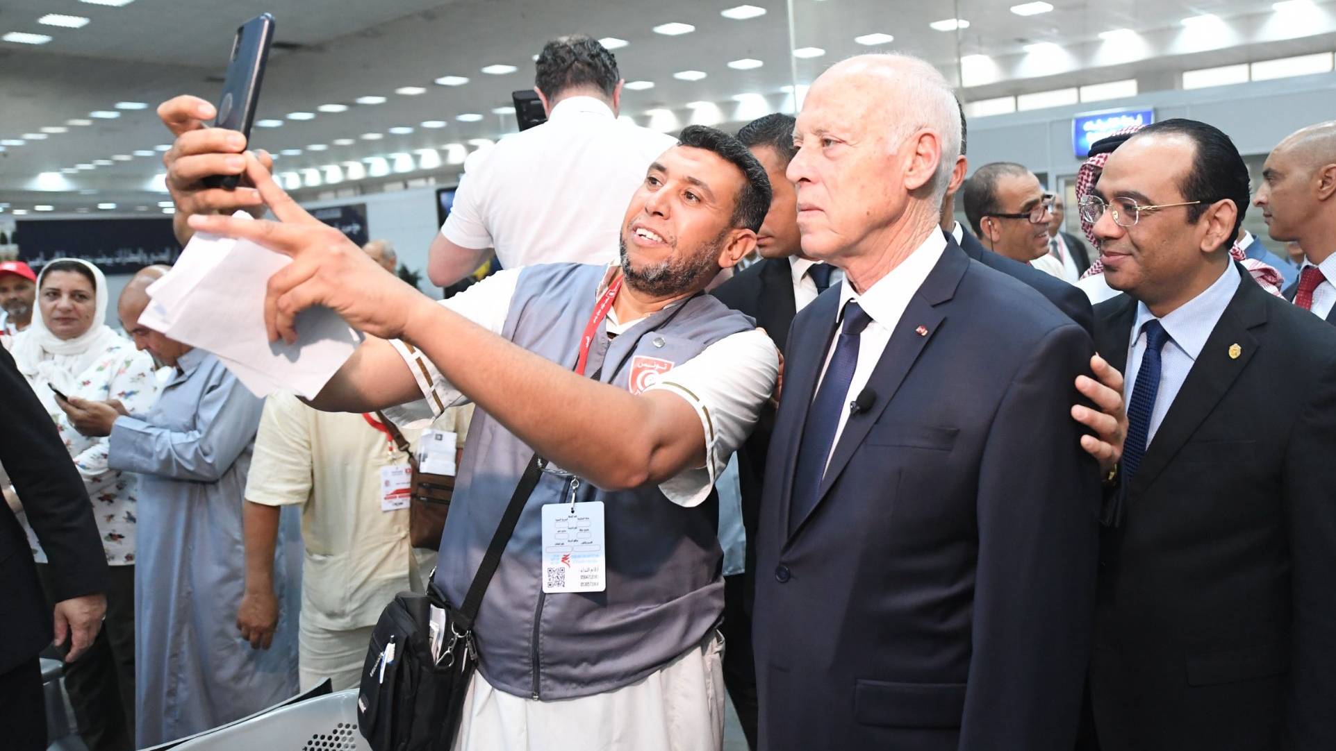 President Kais Saied posing for a selfie with a Tunisia pilgrim at Tunis airport, 21 June 2022 (Twitter/Tunisian Presidency)