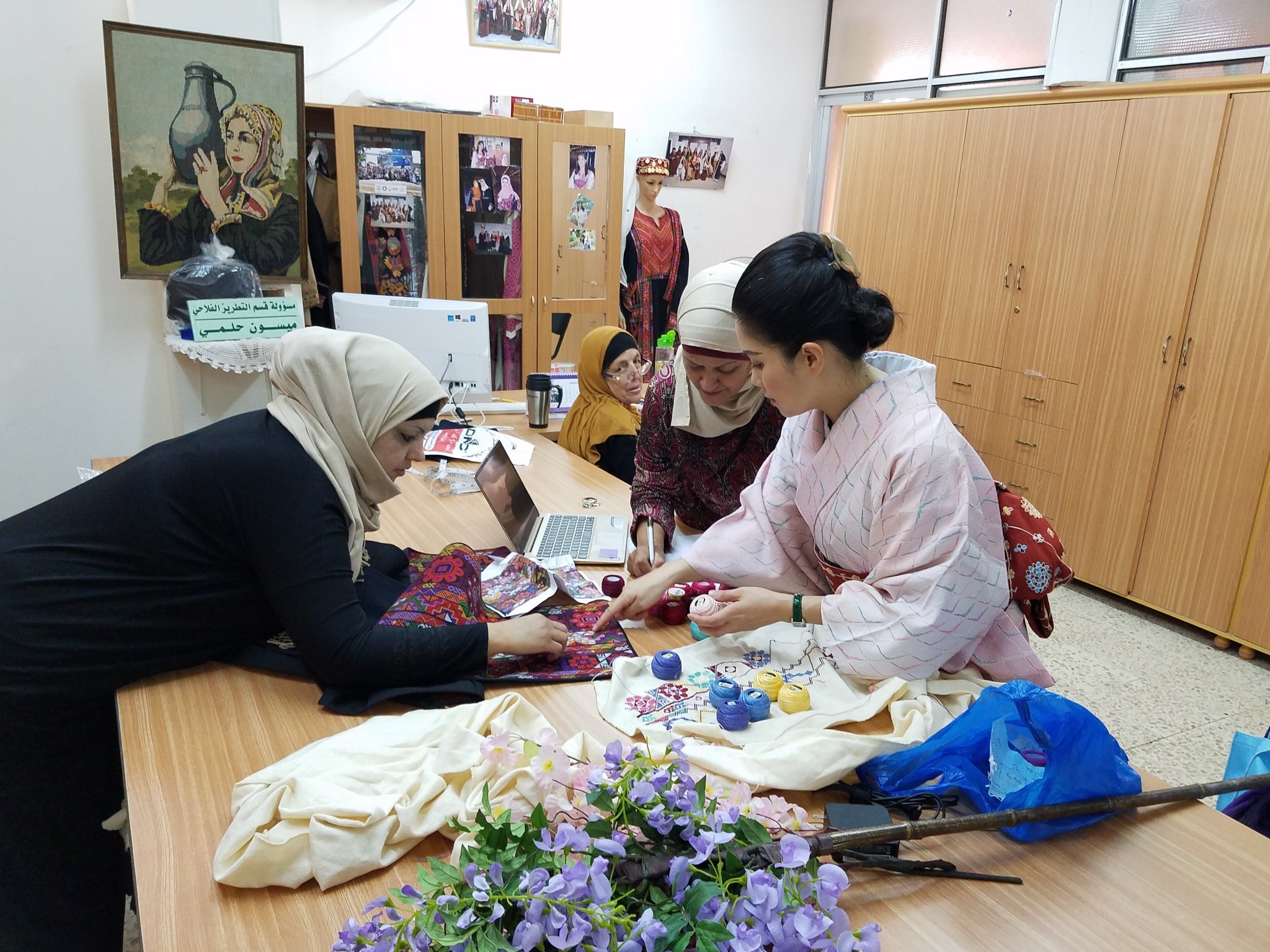Maki Yamamoto examine la progression du tatriz d’un obi au bureau de The Society of Inash al-Usra à Ramallah (Palestinian Embroidery Obi Project)