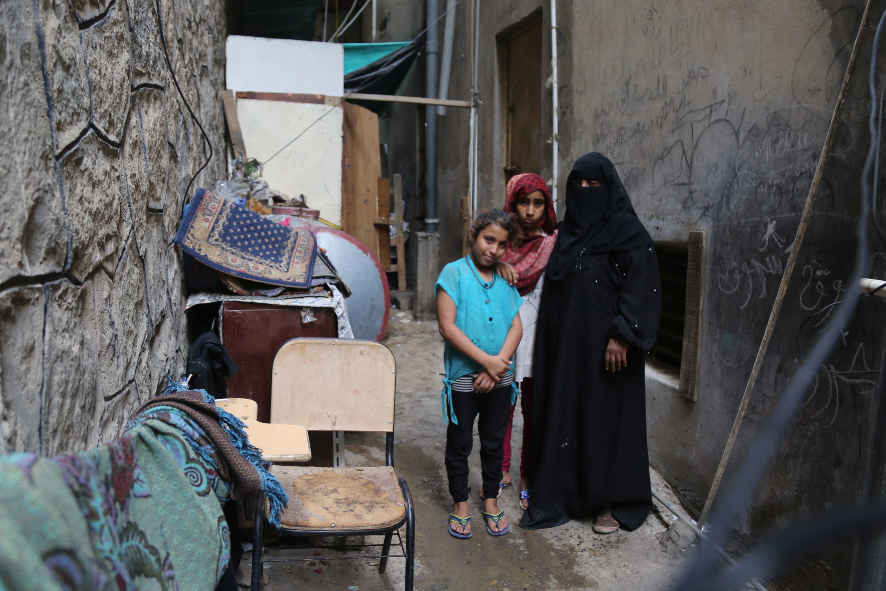 Sama, left, her aunt Thikra, right, and one of Sama's sisters. Thikra has taken in the five sisters after their parents died. (MEE/ Khalid al-Banna)