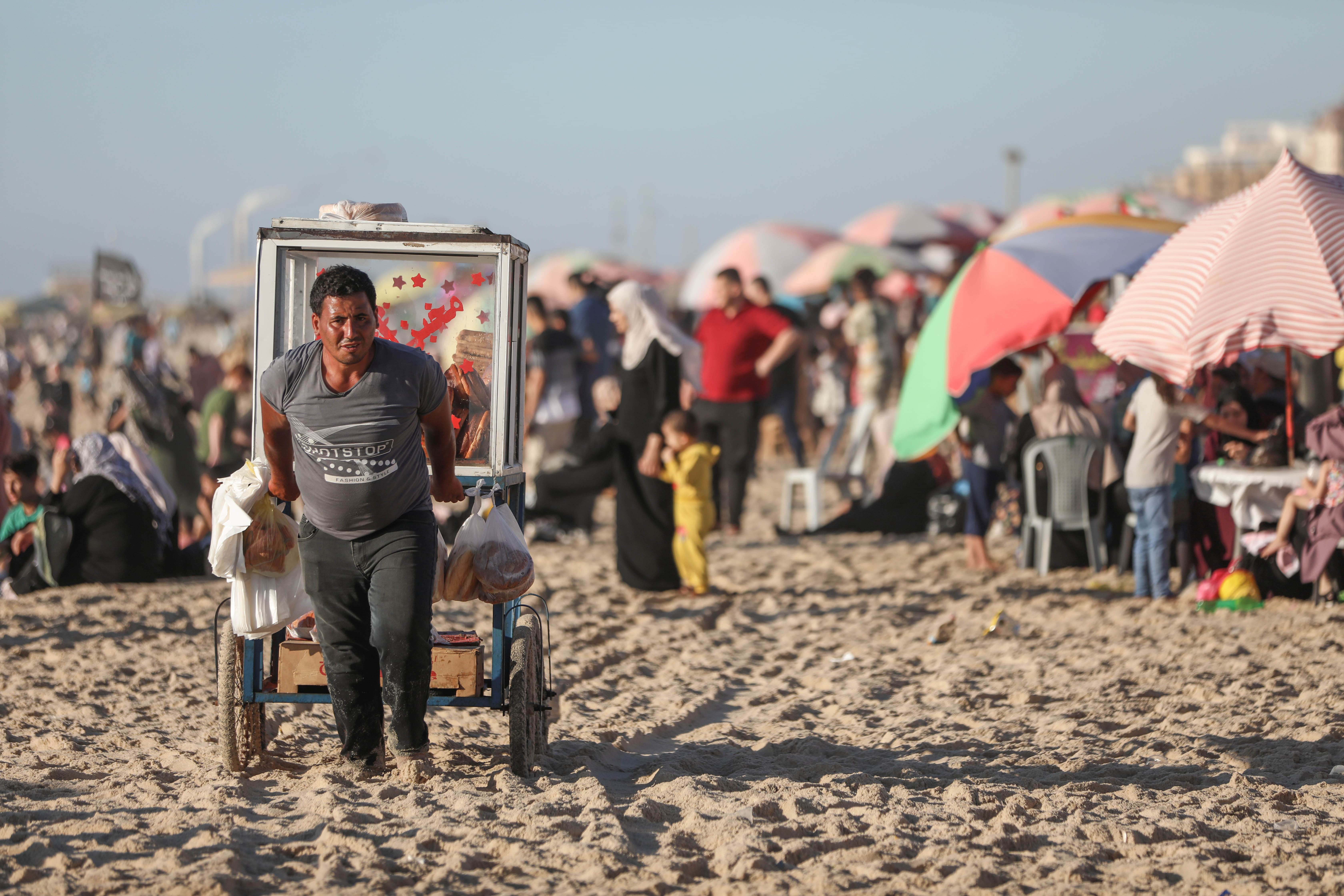 A Palestinian street vendor selling baked goods on Gaza City's beach on 14 June 2022 (MEE/Mohammed al-Hajjar)