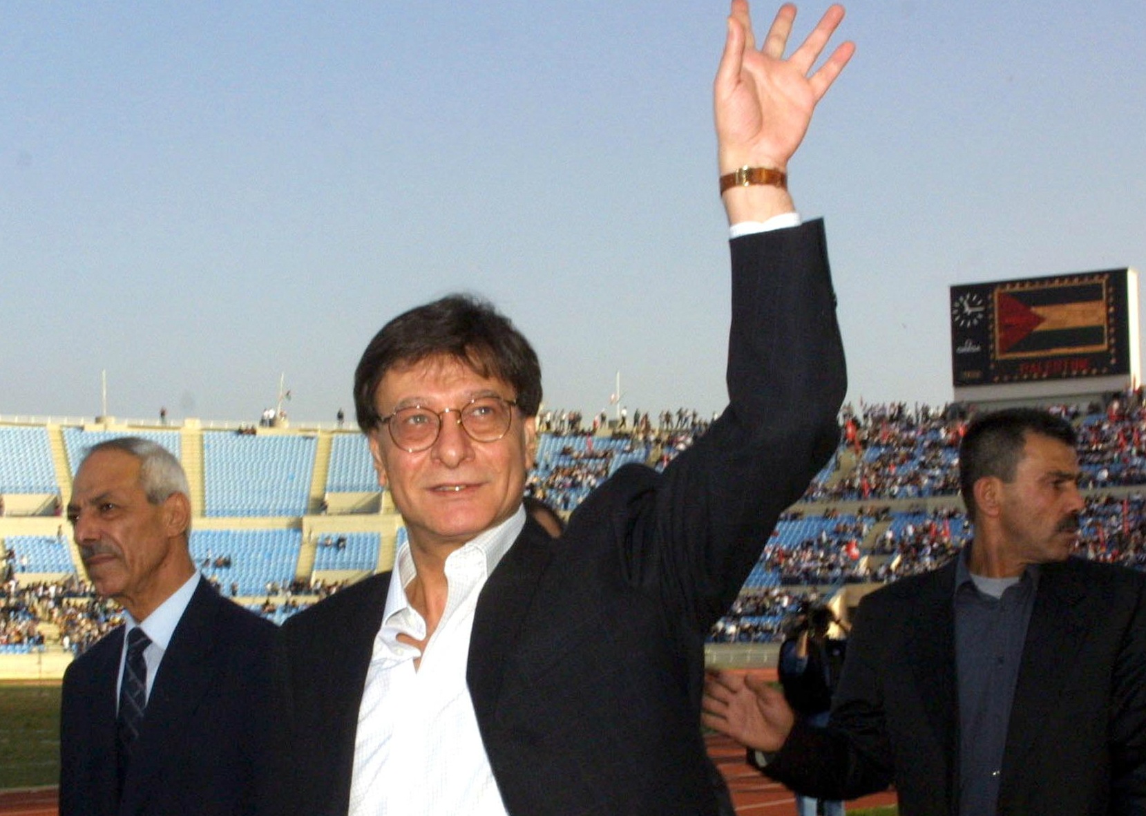 Palestinian poet Mahmoud Darwish waves to crowds before a concert and poetry reading in Beirut in April 2002 (AFP)