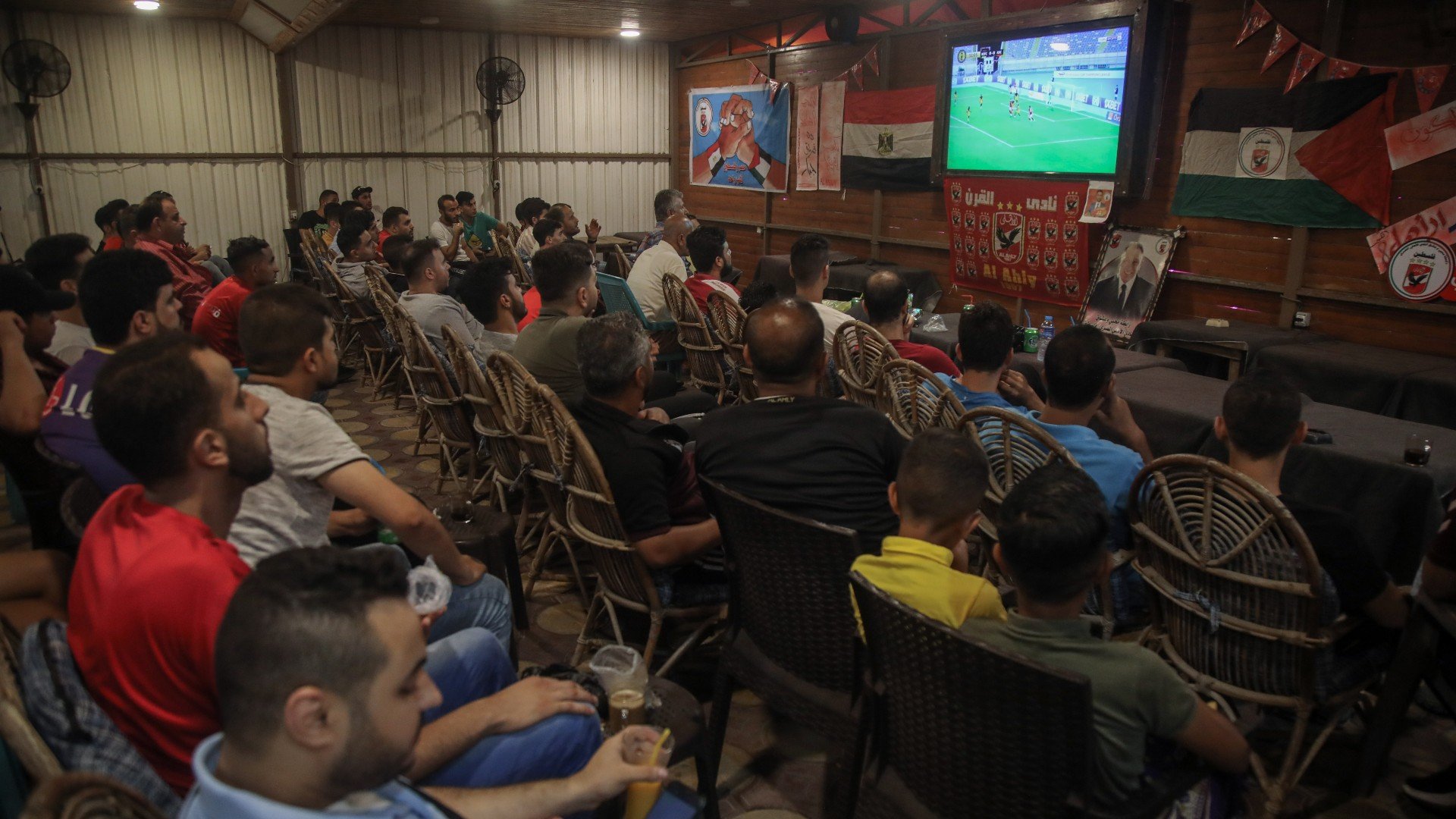 Palestinians watch a football match at a cafe in the besieged Gaza Strip (MEE/Muhammed Hajjar)
