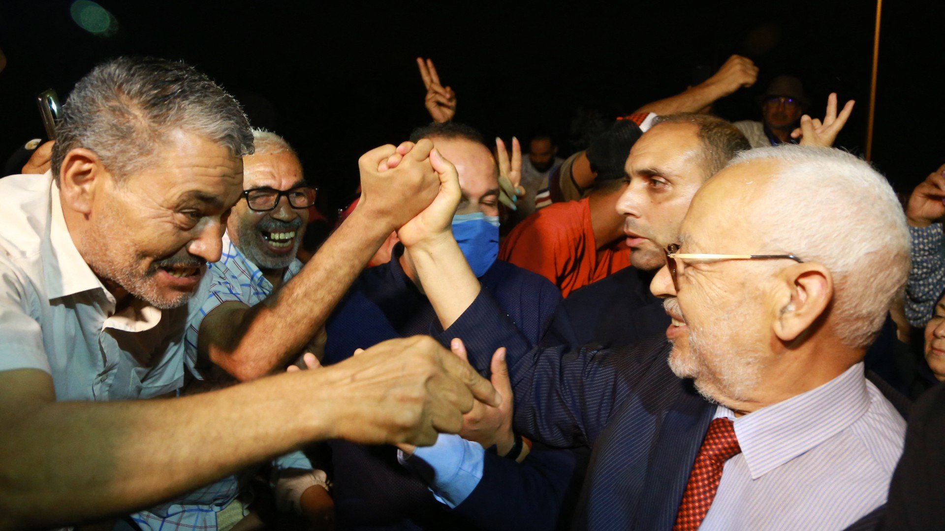 Rached Ghannouchi, head of Tunisia's Islamist Ennahda party, greets his supporters as he leaves the office of Tunisia's counter-terrorism prosecutor in Tunis on July 19, 2022.