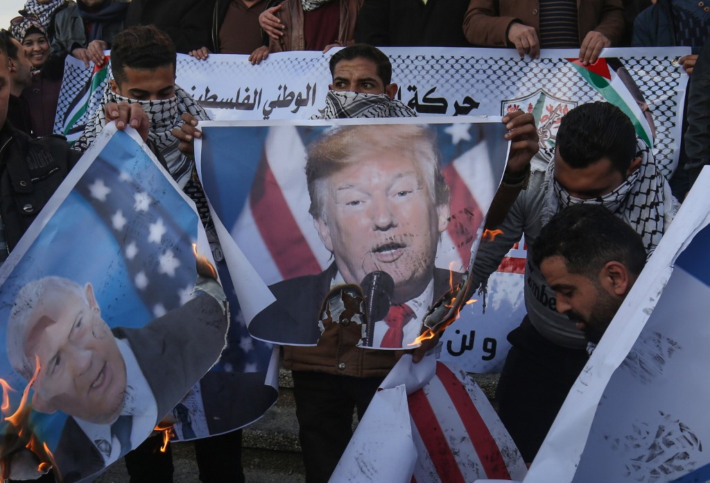Palestinian demonstrators burn images of US President Donald Trump and Israeli Prime Minister Benjamin Netanyahu in Rafah, Gaza, on 29 January (AFP)