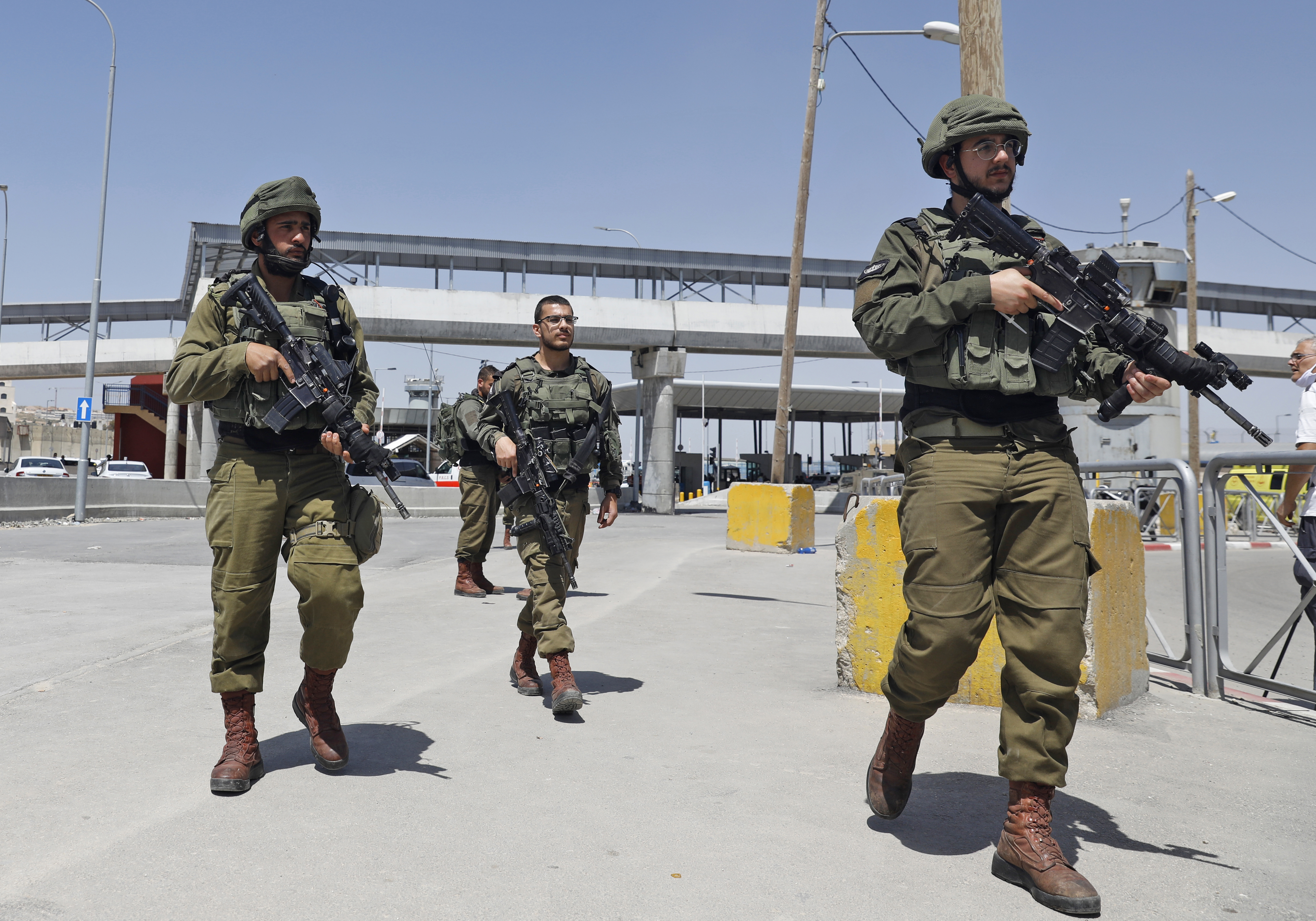 Israeli soldiers gather at the Qalandiya checkpoint in the occupied West Bank on 12 May (AFP)