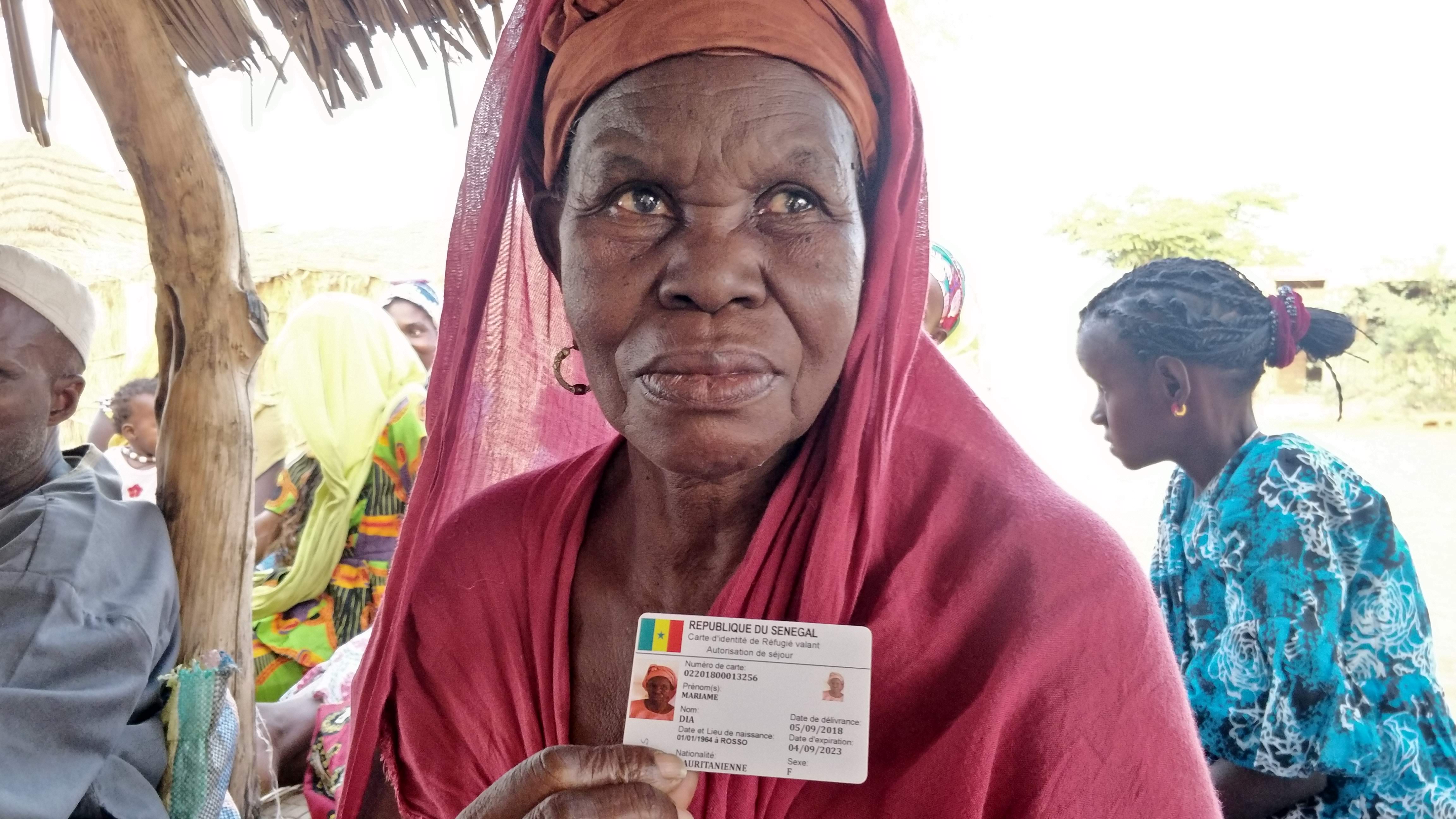 Mauritanian refugee Mariame Dia holds her identity card (MEE/Amandla Thomas-Johnson)