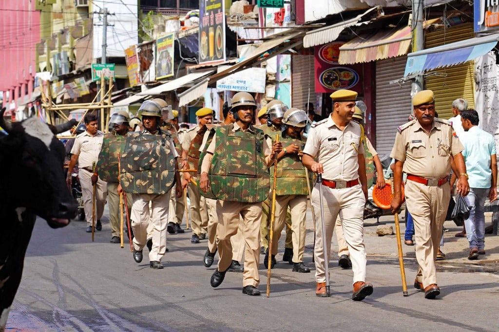Police march through a street in Ajmer, India, on 29 June 2022 (AFP)