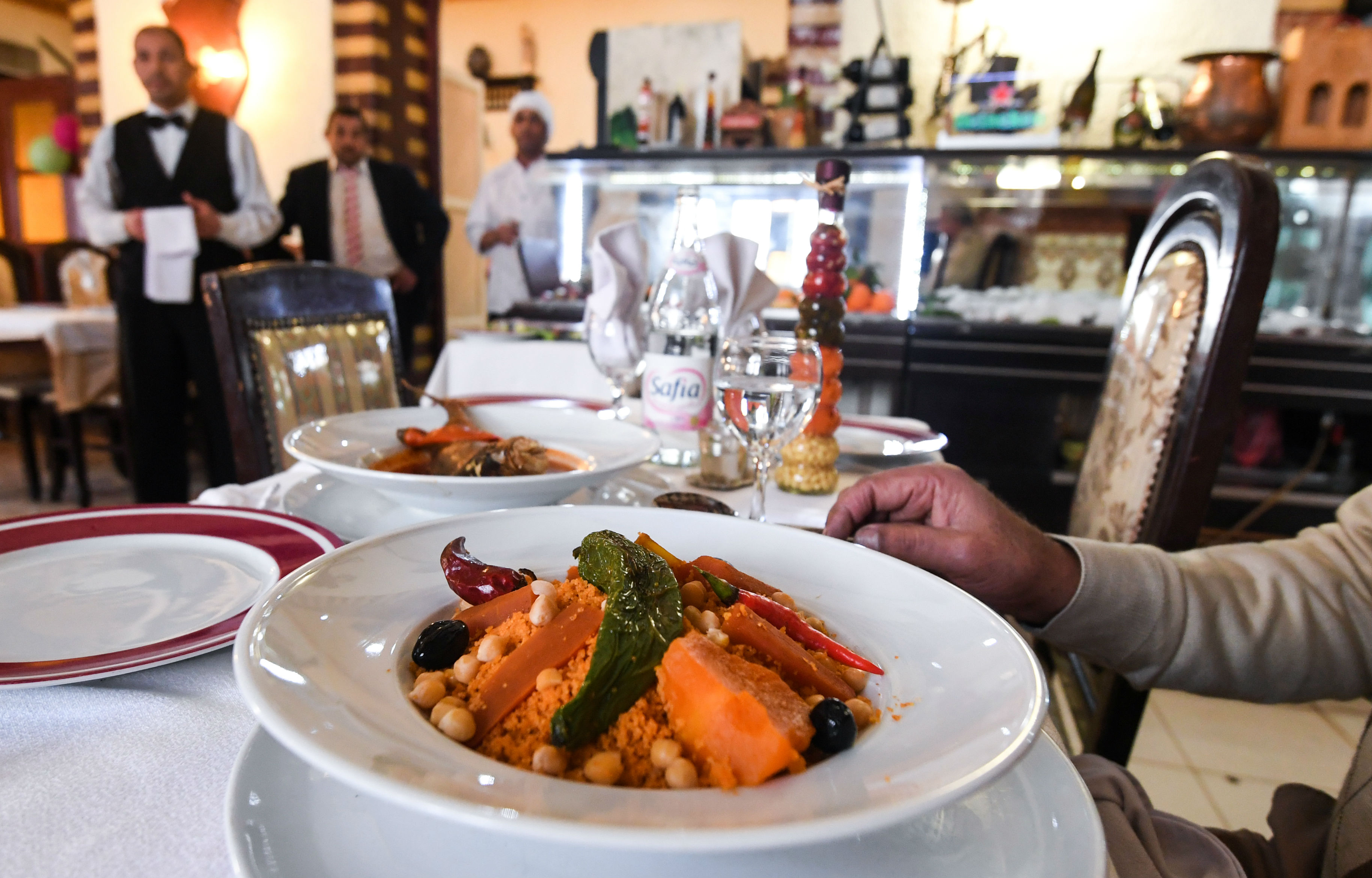 Patrons are served couscous dish at the restaurant L'Orient in Tunis in January 2018 (AFP)