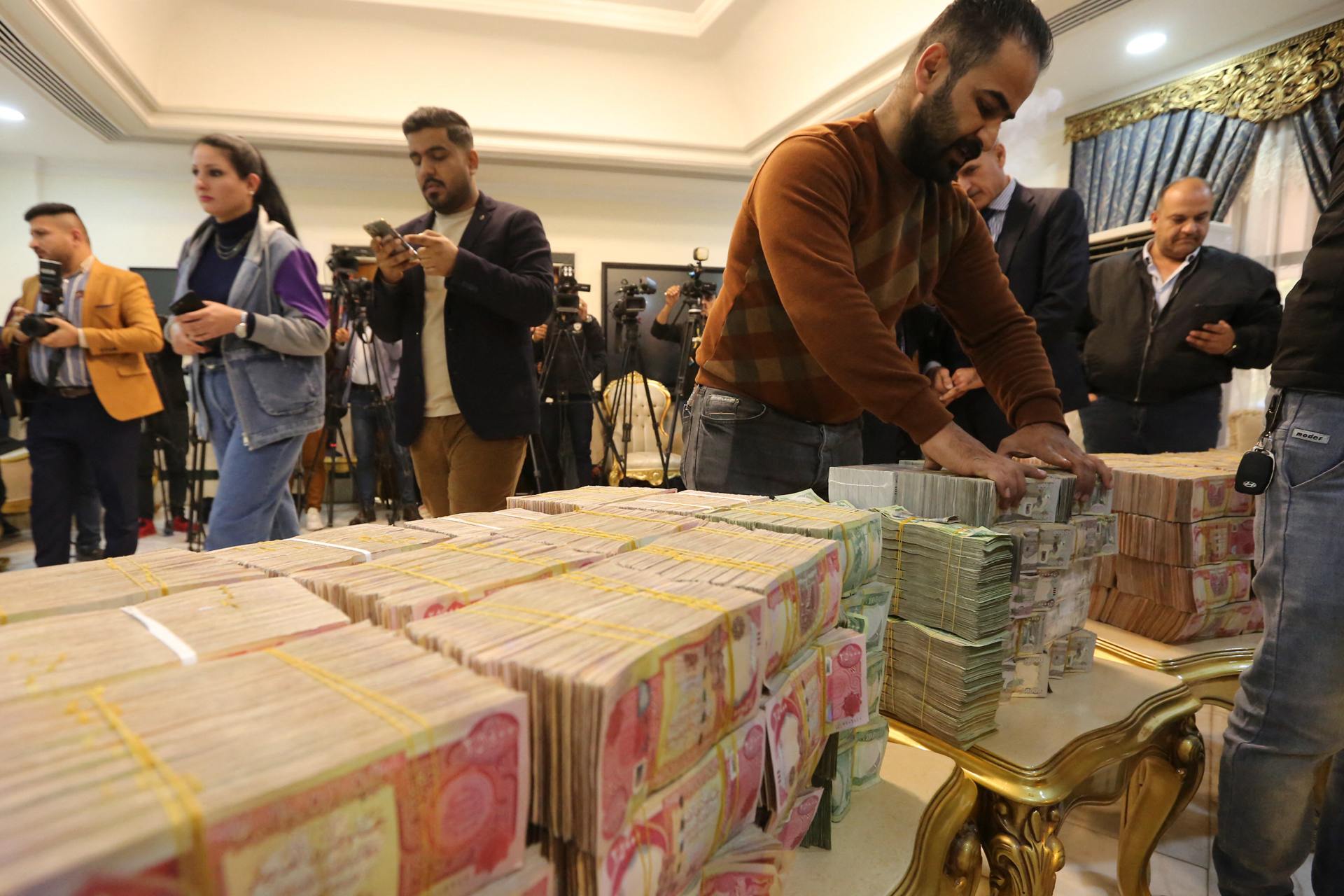 Banknotes are displayed at a press conference announcing the recovery of 2.5bn dinars ($2.6m) in Baghdad on 3 January (AFP)