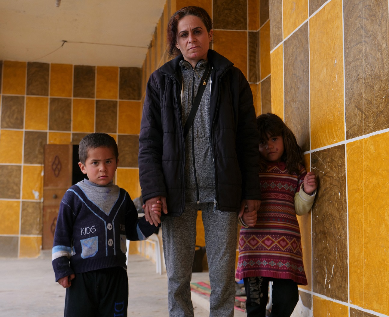Jane, seen with her two children Ahmed and Farida, says the Yazidis didn't dare to declare their true identity when they arrived at the al-Hol camp (MEE/Ines Daif)