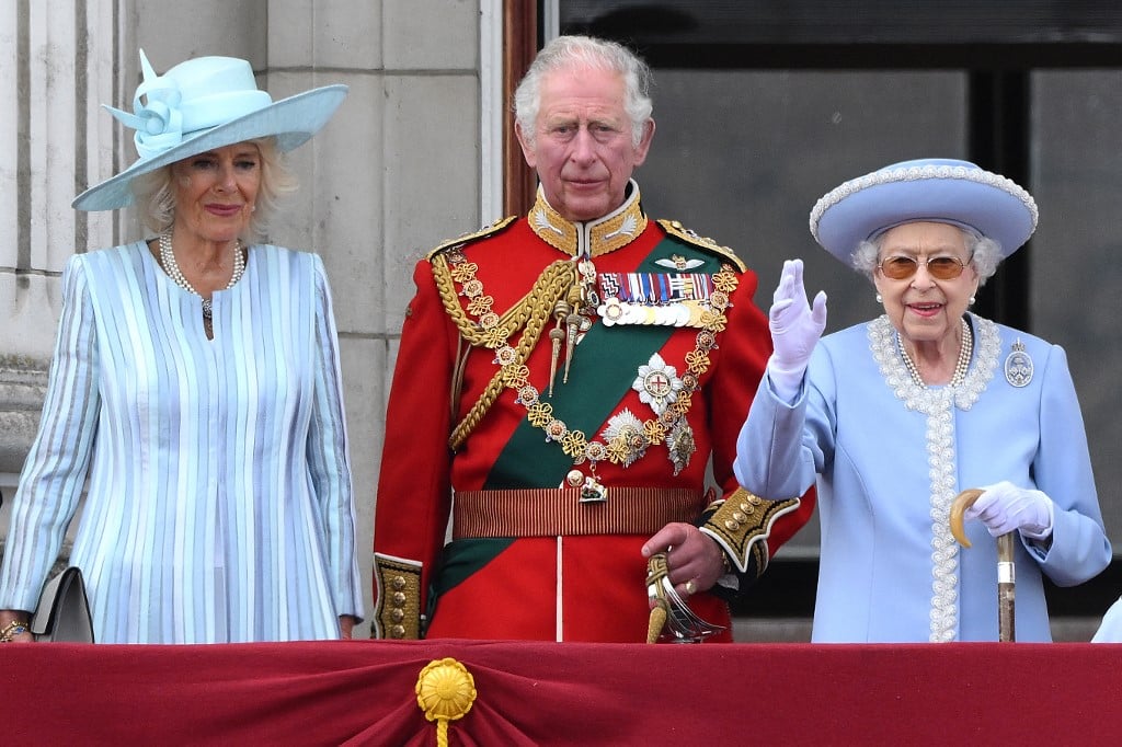 Queen Elizabeth II stands with Camilla, Duchess of Cornwall, and Prince Charles at Buckingham Palace in London on 2 June 2022 (AFP)