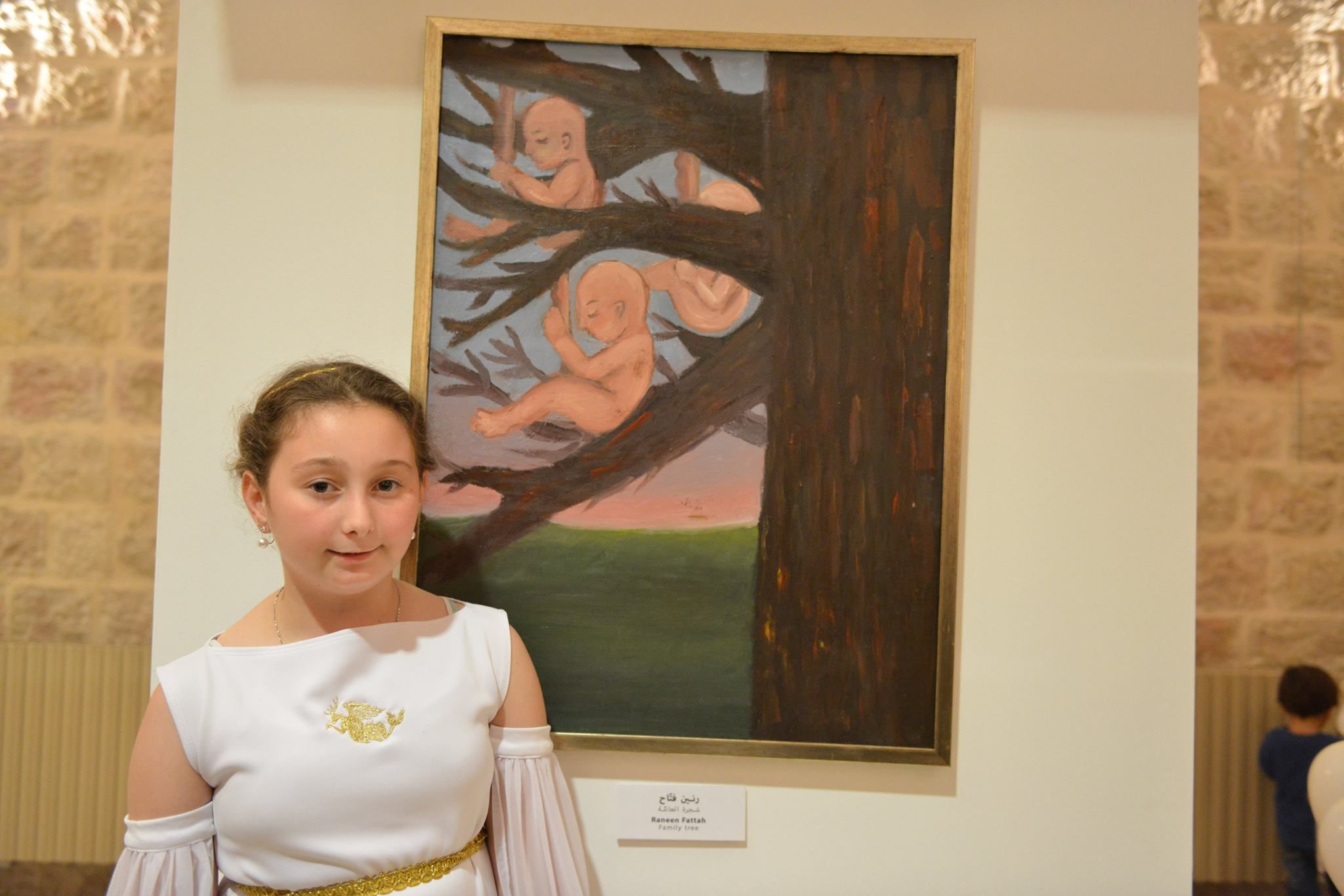 Une jeune participante à un atelier du Conseil de la fiction pose devant une peinture à l’huile sur toile qu’elle a réalisée intitulée « Family Tree » (Conseil de la fiction)