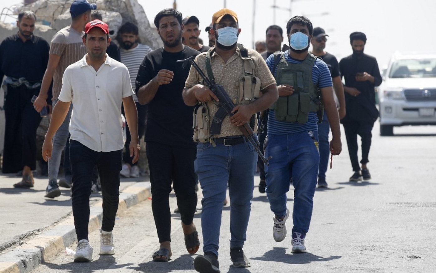 Des membres de Saraya al-Salam (Brigade de la paix), la branche militaire affiliée au religieux chiite Moqtada al-Sadr, en train de se retirer de la Zone verte de Bagdad le 30 août 2022 (AFP/Ahmad Al-rubaye)