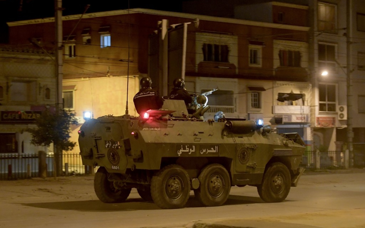 Des membres de la Garde nationale tunisienne dans leur véhicule blindé au milieu d’affrontements avec des manifestants dans le quartier d’Ettadhamen, à Tunis, le 17 janvier 2021 (AFP)