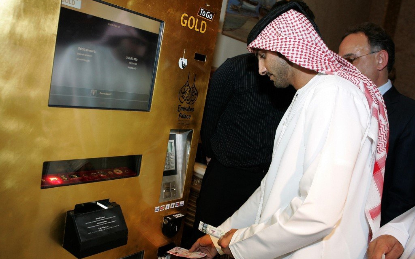 Un client émirati essaie le distributeur automatique « Gold to Go » à l’hôtel Emirates Palace d’Abou Dabi, en mai 2010 (AFP)