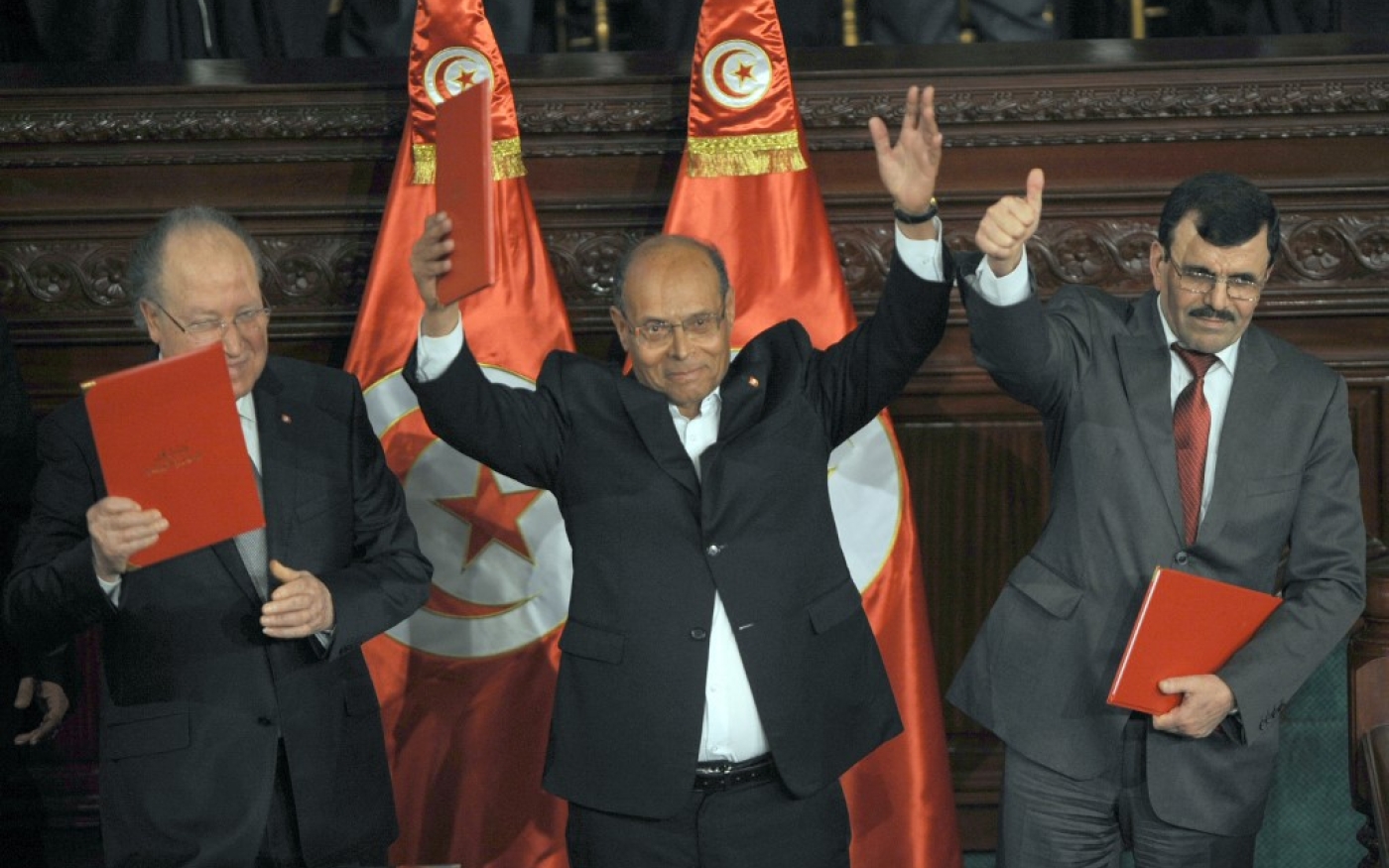 Le président Moncef Marzouki, le président de l’ANC Mustapha Ben Jaafar et le Premier ministre sortant Ali Larayedh posent avec la nouvelle Constitution, le 27 janvier 2014 (AFP/Fethi Belaïd)