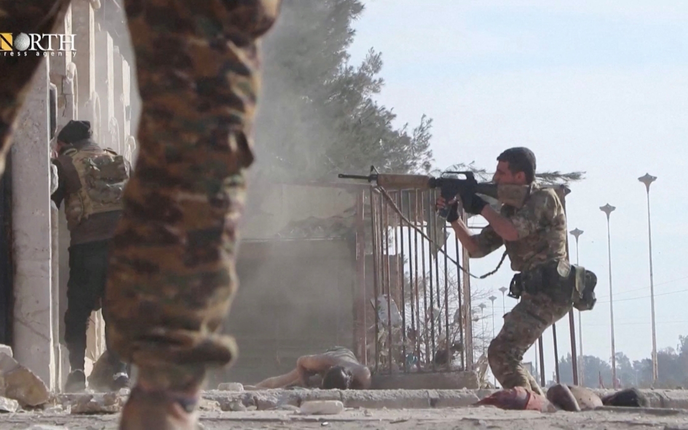 Un membre des Forces démocratiques syriennes braque son arme à l’extérieur d’une prison au cours d’affrontements avec des combattants de l’État islamique à Hassaké (Syrie), le 22 janvier 2022 (North Press Agency/Reuters)