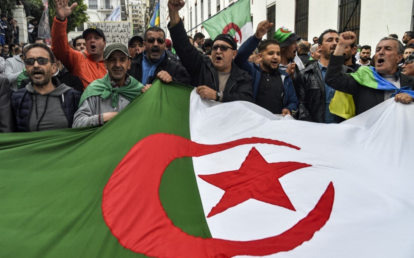 Des manifestants agitent le drapeau algérien à Alger, en mars 2020 (AFP)