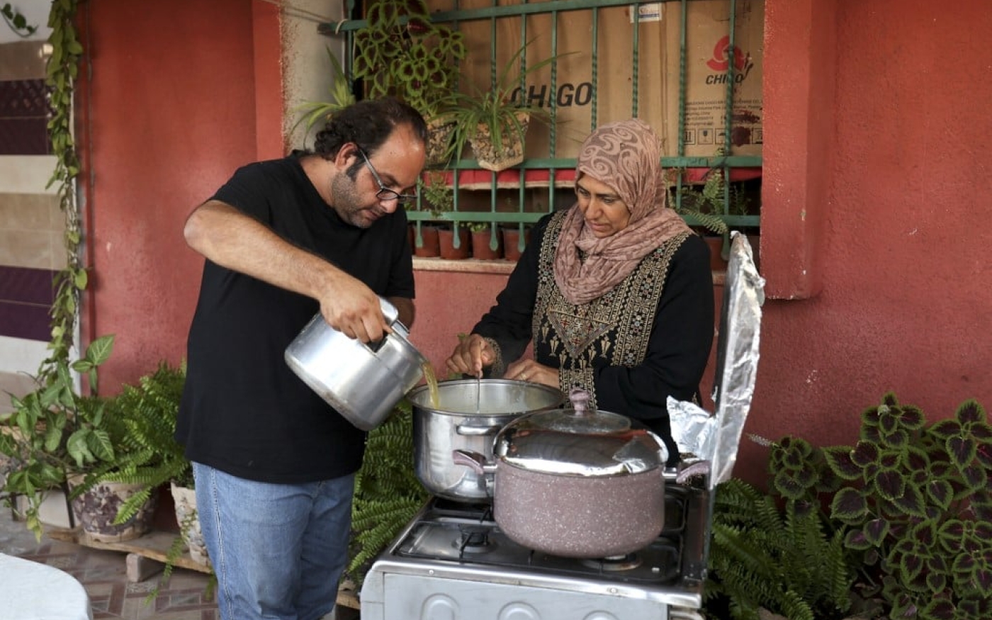 Le chef Fadi Kattan cuisine devant la caméra pendant un tournage pour sa chaîne YouTube, où il partage ses techniques avec plusieurs grands-mères palestiniennes (AFP)