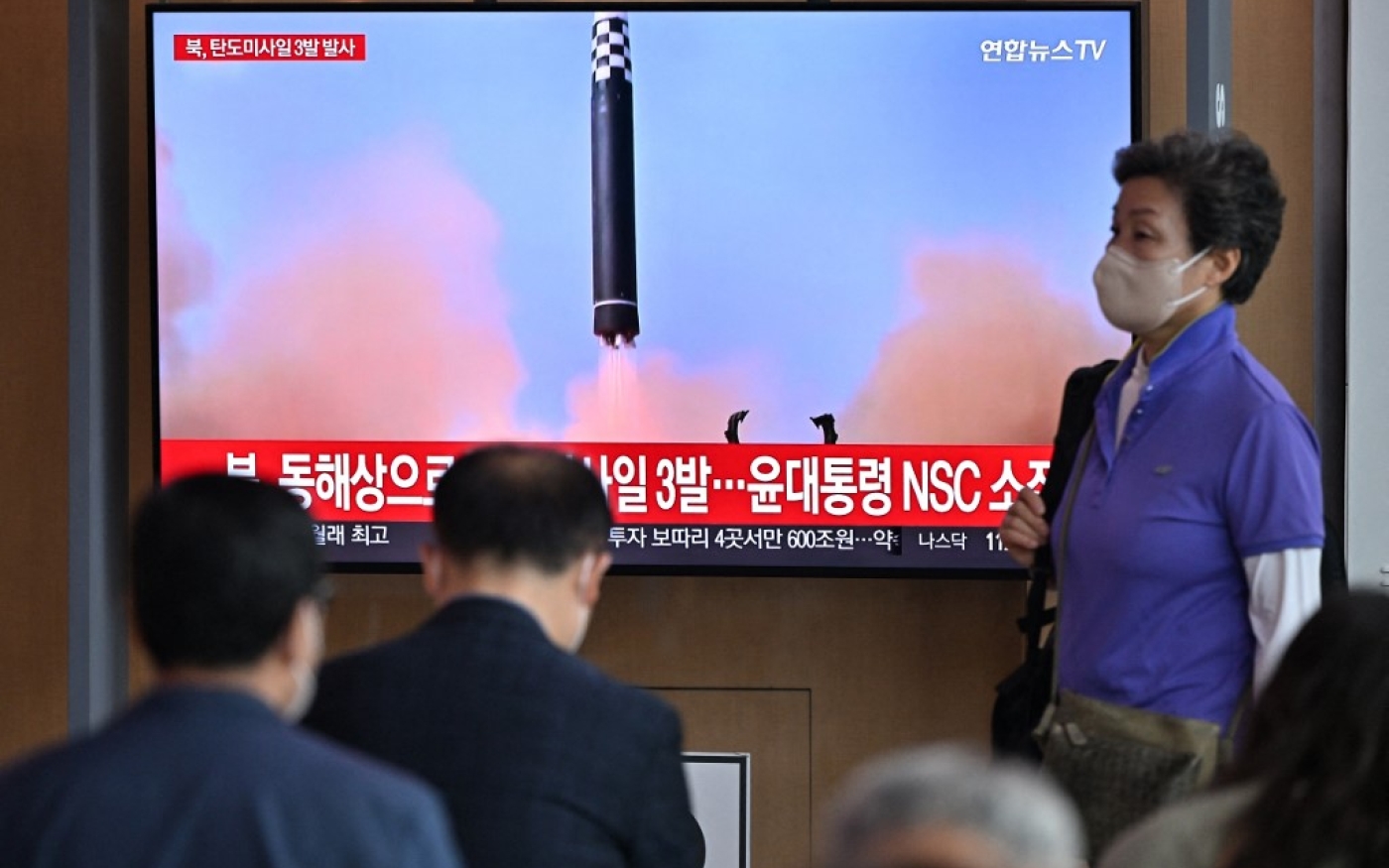 Des Coréens regardent un écran de télévision montrant une émission d’actualités avec des images d’archives d’un test de missile nord-coréen, dans une gare de Séoul le 25 mai 2022, après que la Corée du Nord a tiré trois missiles balistiques vers la mer du Japon, selon l’armée sud-coréenne (AFP/Jung Yeon-Je) 