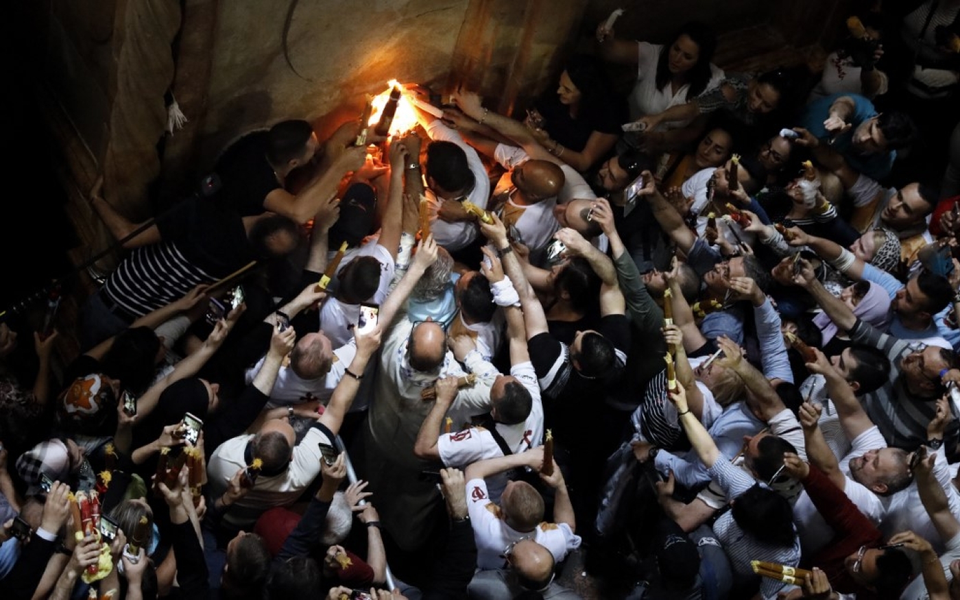 Des fidèles allument leur cierge au feu sacré dans l’église du Saint-Sépulcre dans la vieille ville de Jérusalem (AFP)