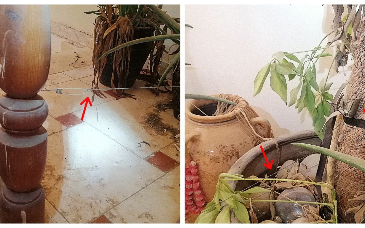 Dans un couloir, un fil de détente est tendu entre un escalier et une plante en pot, qui dissimule une grenade (photo fournie)