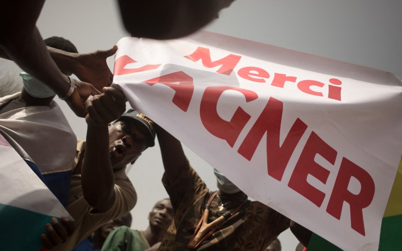 Des manifestants agitent une banderole pour remercier les mercenaires russes de Wagner et célébrer l’annonce par la France du retrait de ses troupes, à Bamako, le 19 février 2022 (AFP/Florent Vergnes)