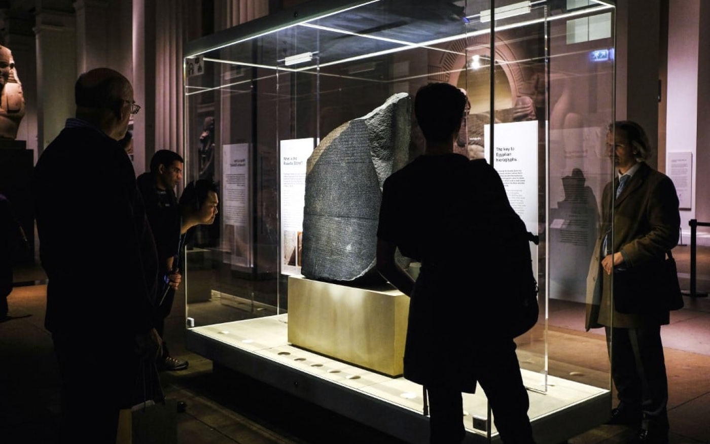 Des touristes observent la pierre de Rosette au British Museum à Londres (AFP)