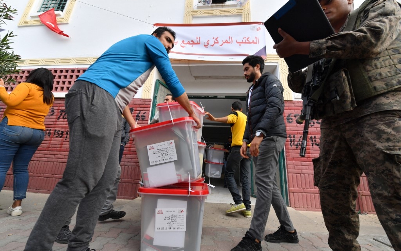 Des urnes sont manipulées sous la surveillance des militaires, dans L’Ariana, près de Tunis, le 16 décembre 2022 (AFP/Fethi Belaid)