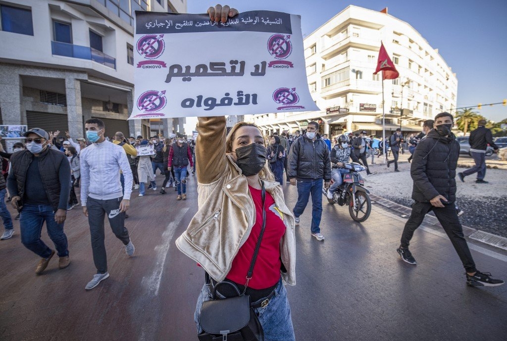 Portant une pancarte « Non au bâillonnement », une manifestante à Rabat, le 7 novembre 2021, dénonce l’obligation du pass sanitaire (AFP/Fadel Senna)