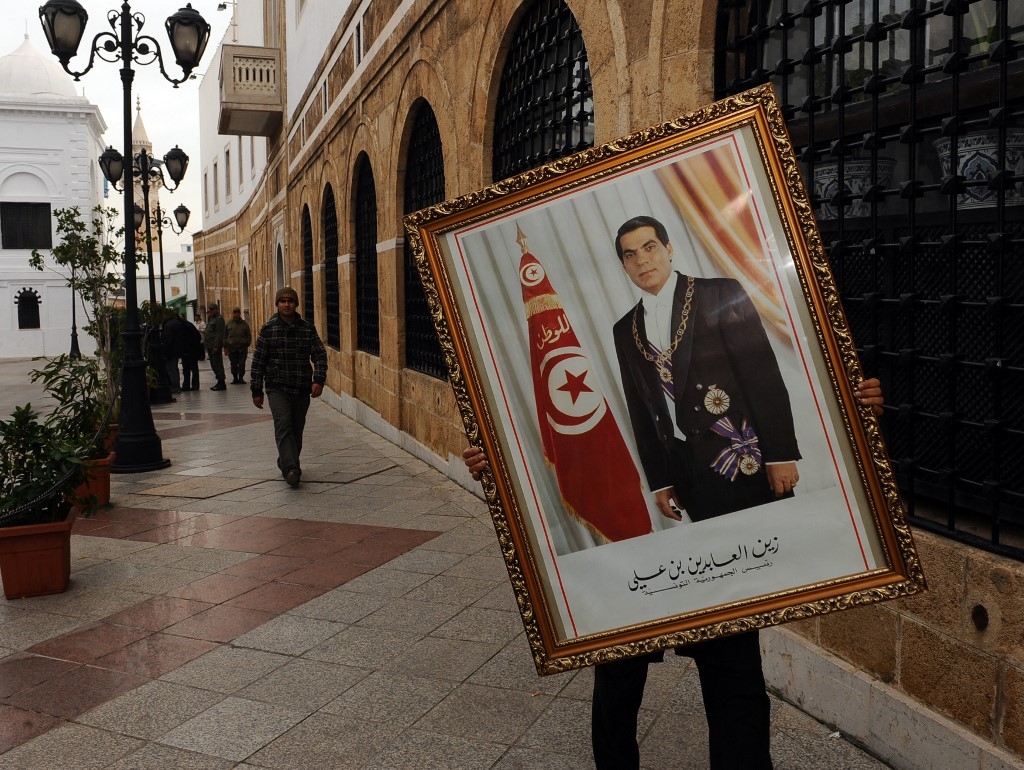 rois jours après la fuite de Ben Ali, un employé du Premier ministère à Tunis retire un portrait de l’ex-président déchu (AFP/Fethi Belaid)