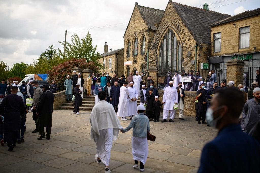 Muslim worshippers leave after the Eid Al-Fitr prayer, which marks the end of the holy month of Ramadan, at Bradford Central Mosque, northern England, on 13 May 2021 (AFP)