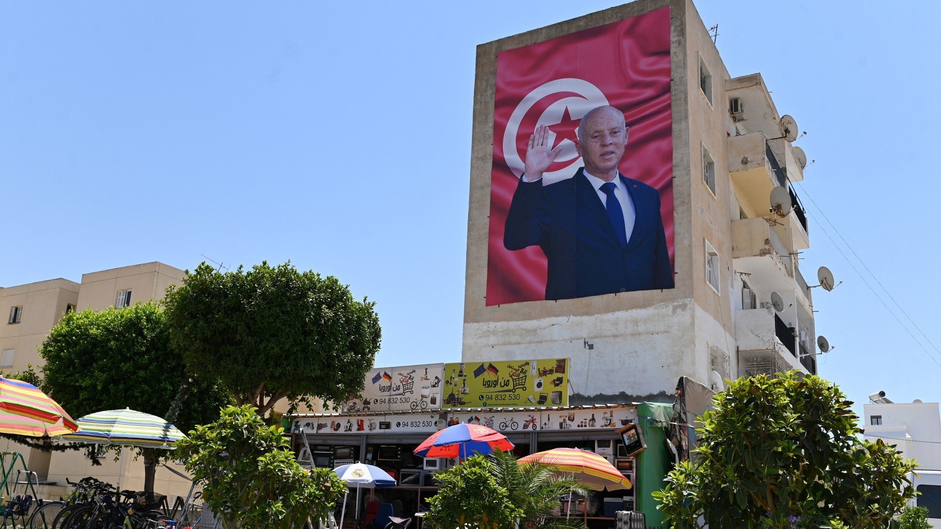 A billboard depicting Tunisia's Kais Saied hangs on the side of a building in the east-central city of Kairouan, on 26 July 2022 (AFP)