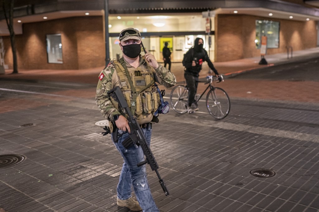 A far-right activist holds an assault rifle during a confrontation with anti-fascists on 8 August 2021 in Portland, Oregon