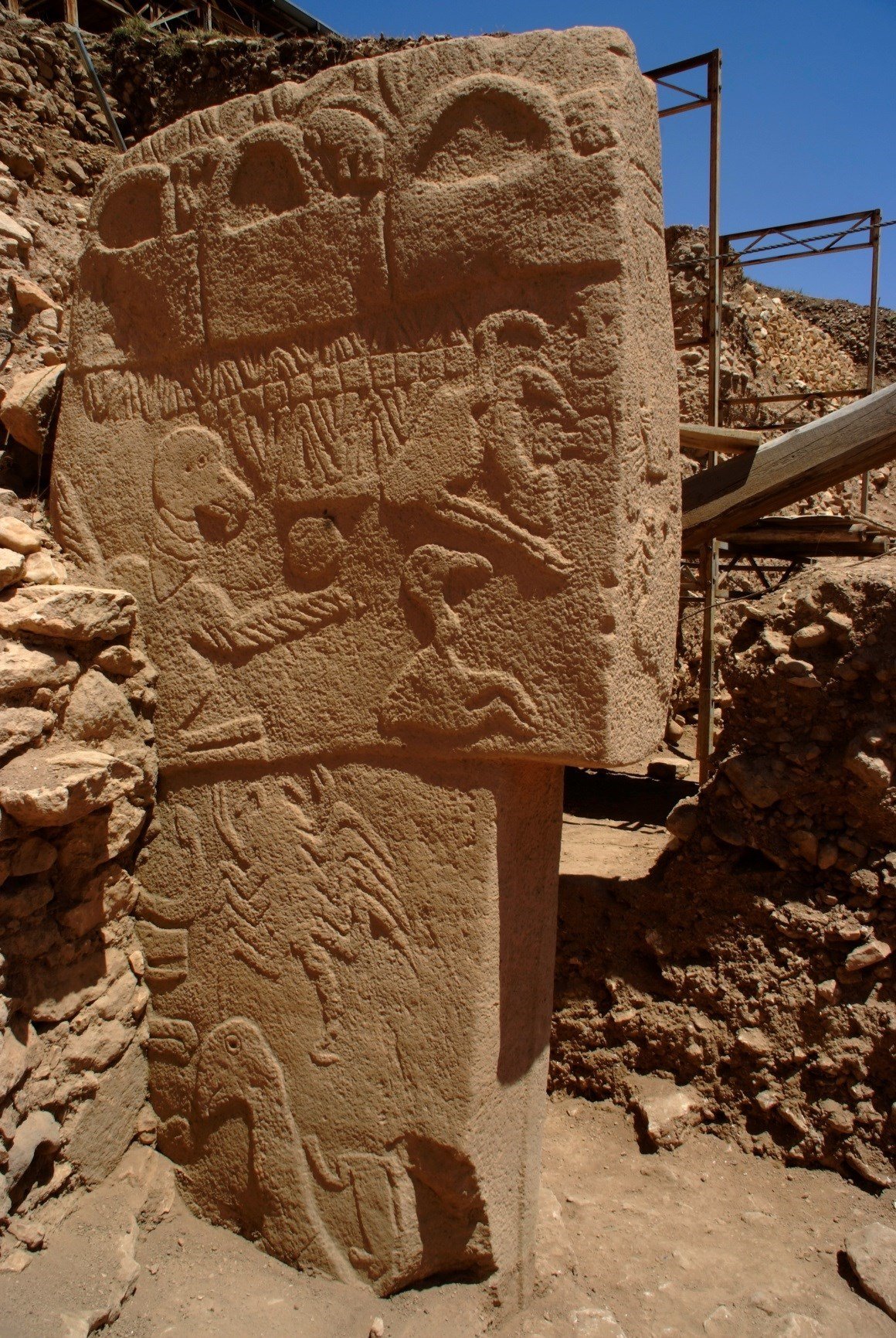 Le pilier 43 dans le bâtiment D montre des bas-reliefs de différents animaux, insectes et une figure humaine ithyphallique (UNESCO/DAI, Göbekli Tepe Project)
